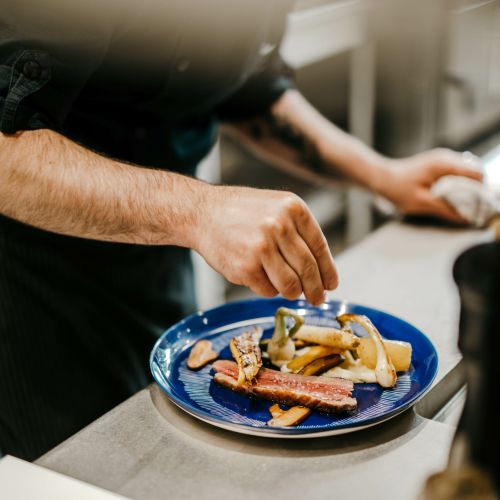 main qui sale un plat